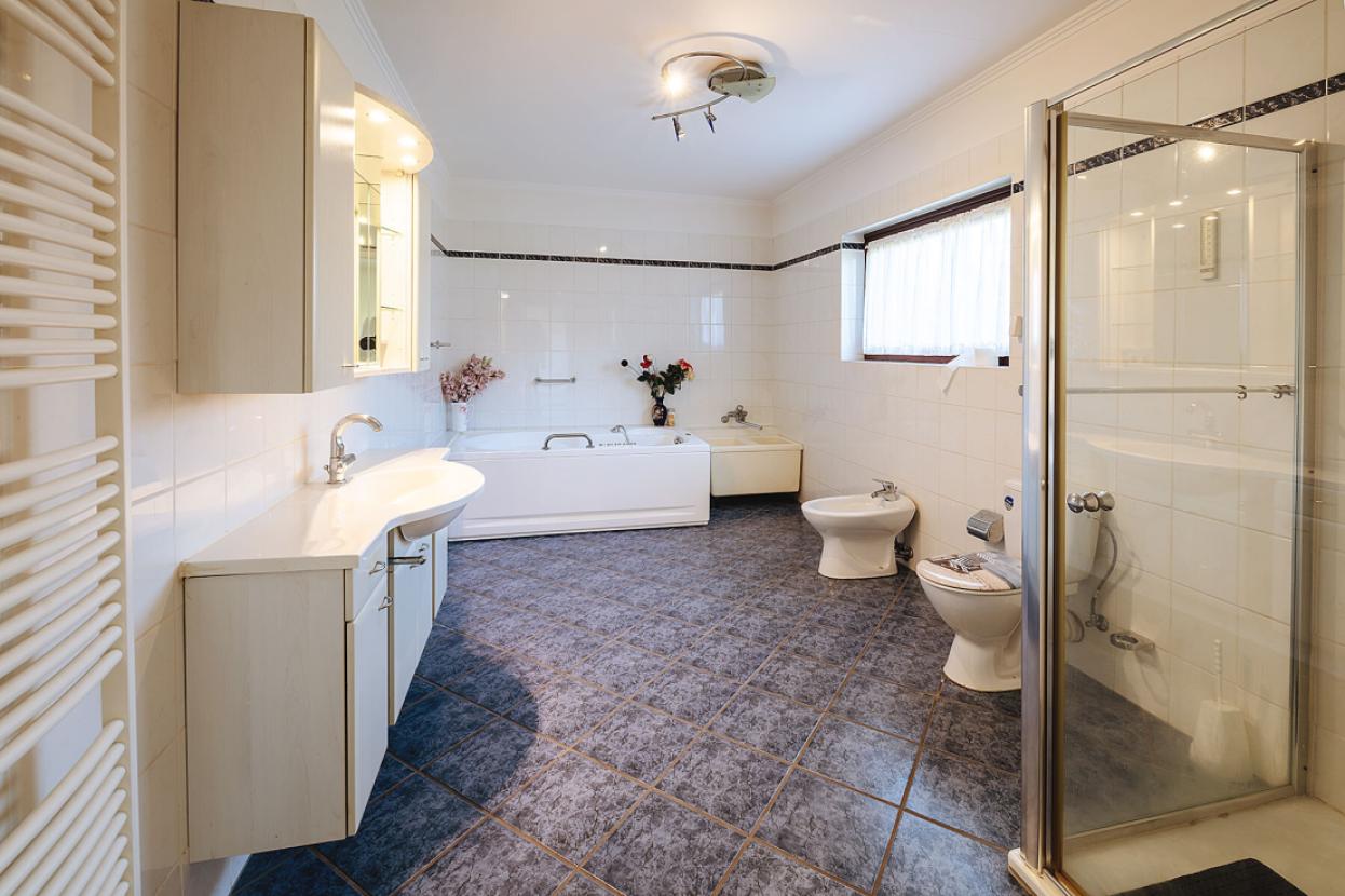 Großes Bad mit Whirlpoolbadewanne und Dusche im EG