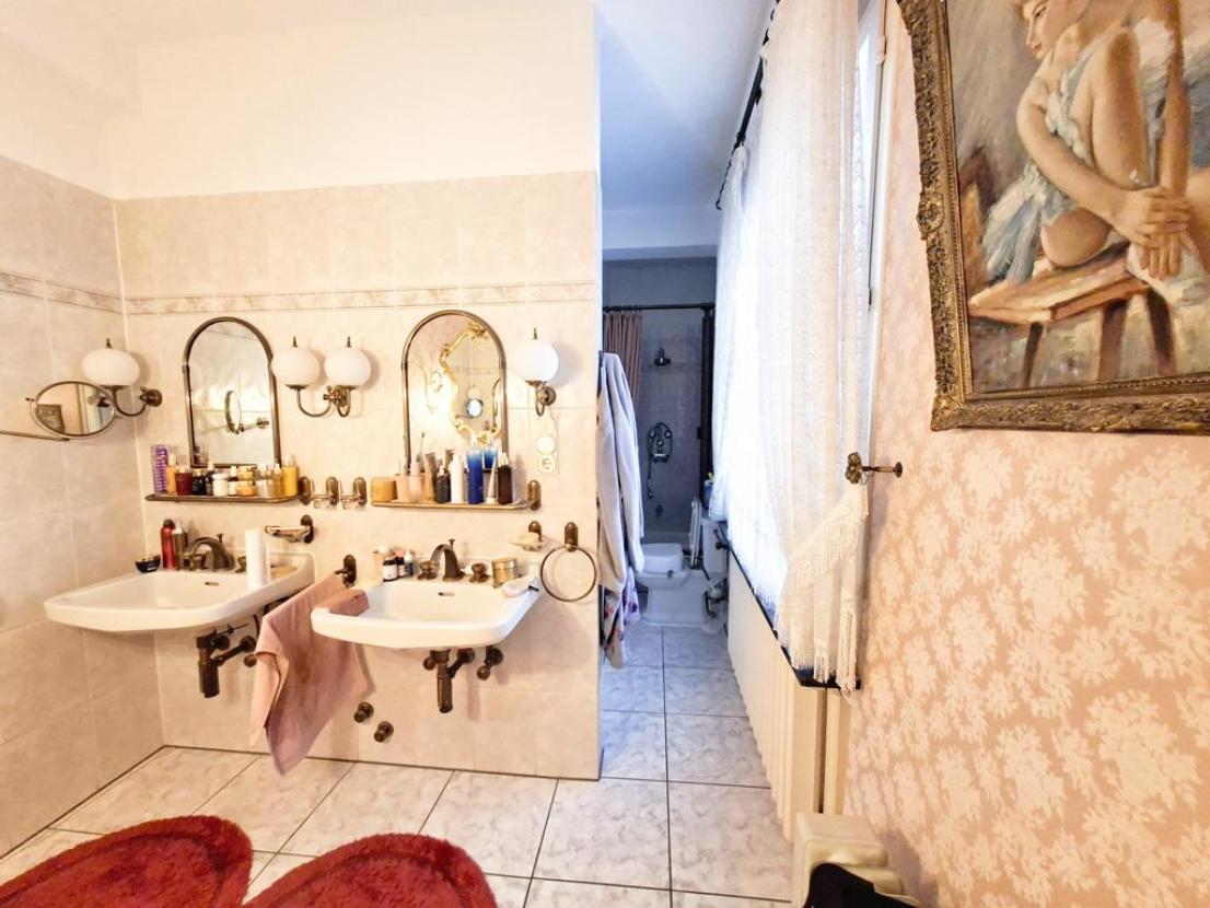 Badezimmer mit Doppelwaschbecken, WC, Dusche und Badewanne