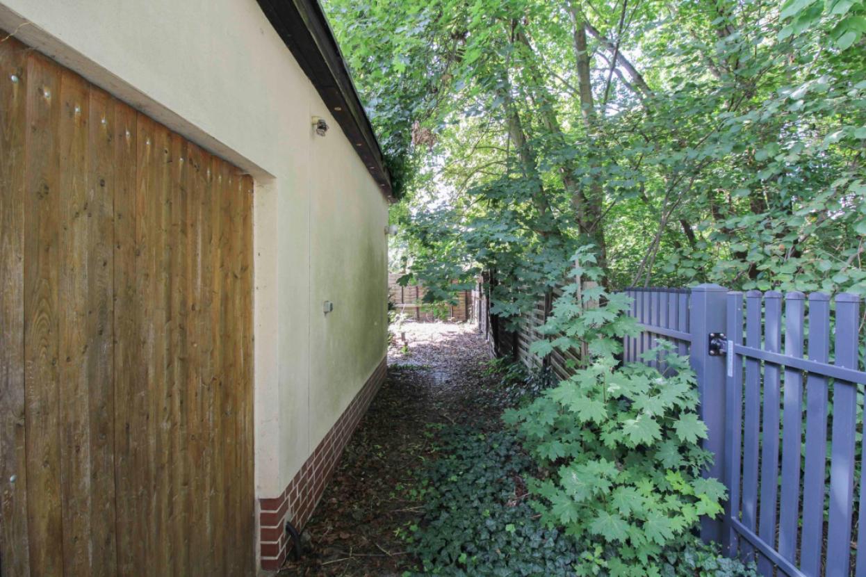 Weg zwischen Zaun und Laube