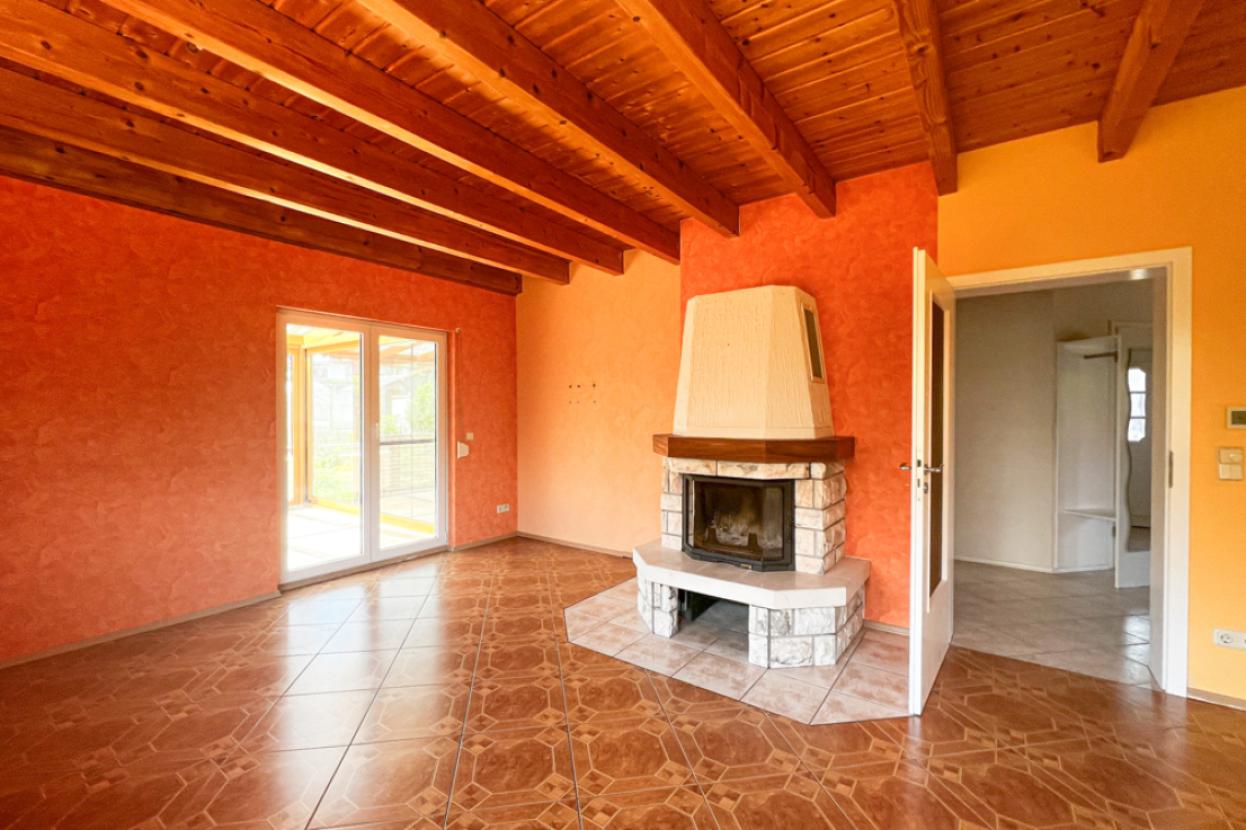 Wohnzimmermit Kamin und anschließenden Wintergarten