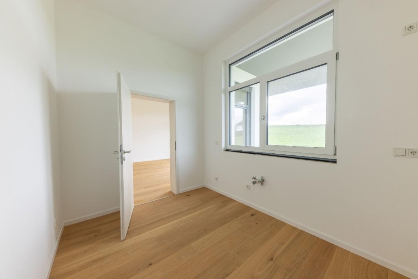 Küche mit Blick nach draußen und Blick durch die Türe ins Wohnzimmer