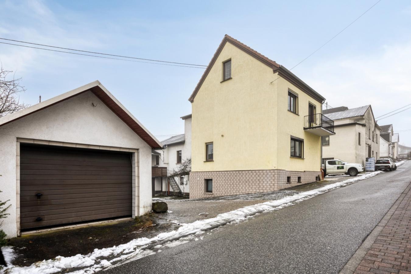 Straßenansicht mit Garage seitlich links