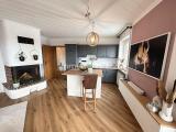 Wohnzimmer mit Kamin und offener Küche