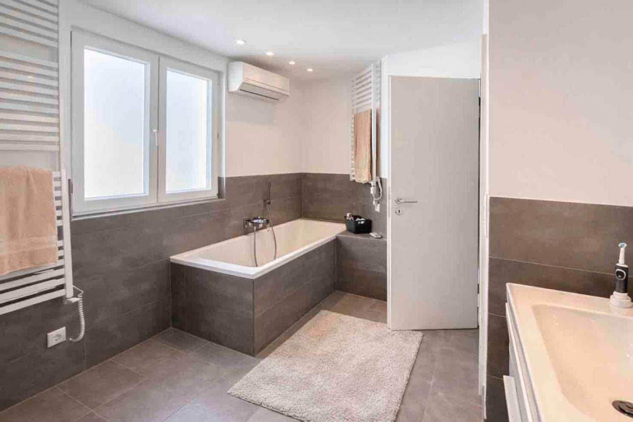 Modernes Tageslichtbad mit Badewanne und Duschtempel