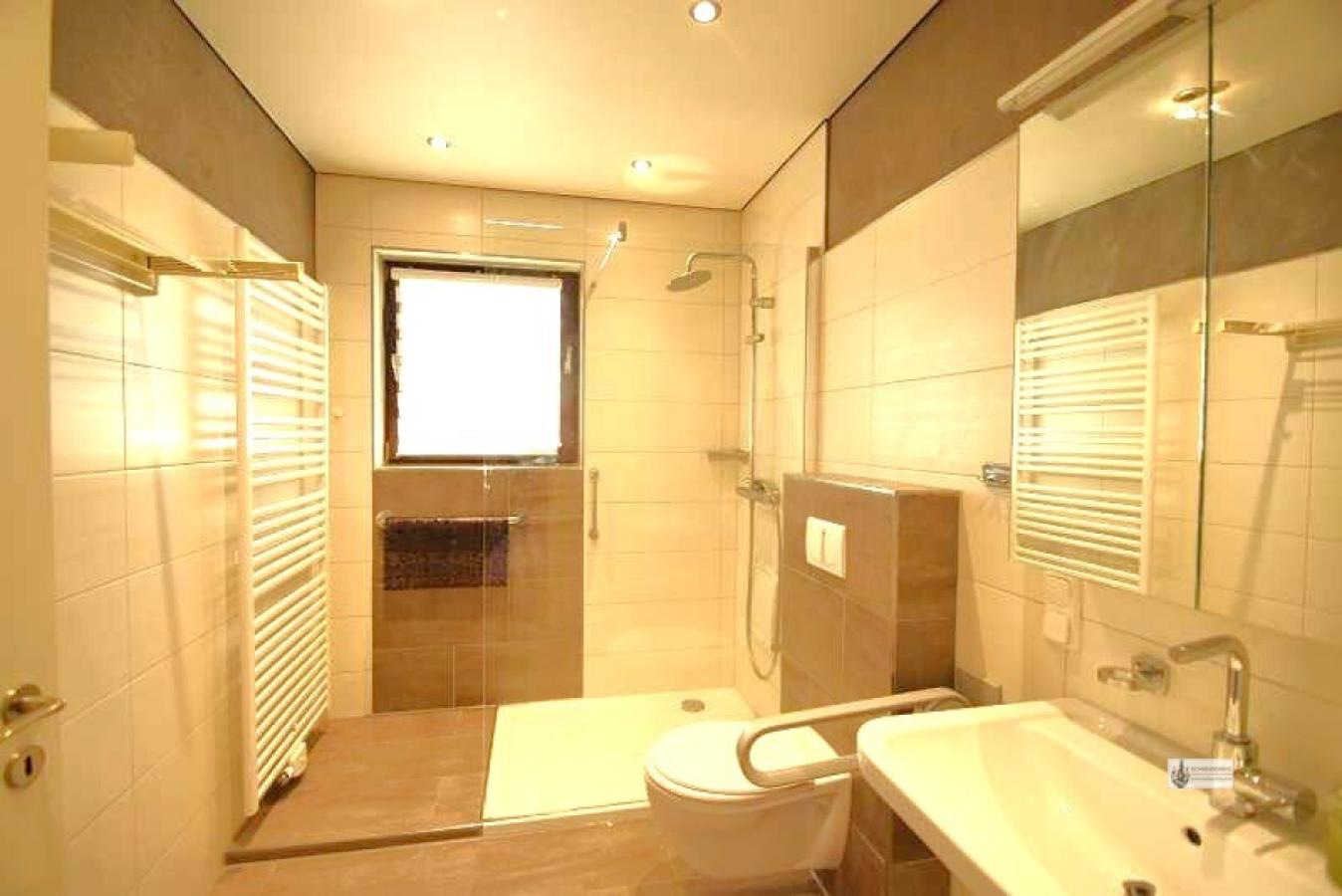 Bad mit Dusche, Glasspritzschutzwand und Handtuchheizkörper