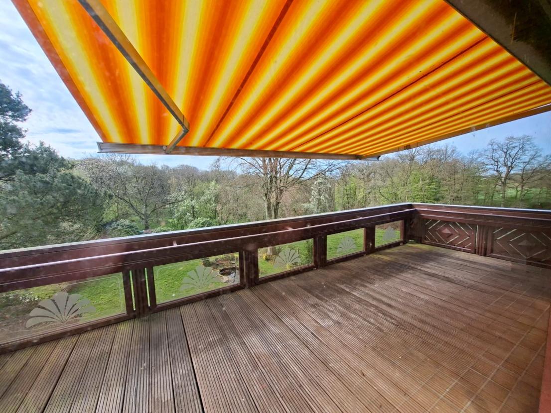 Balkon mit Markise und Blick in den Garten