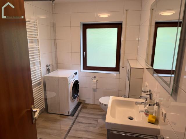 Badezimmer mit Waschmaschine WC und Waschbecken