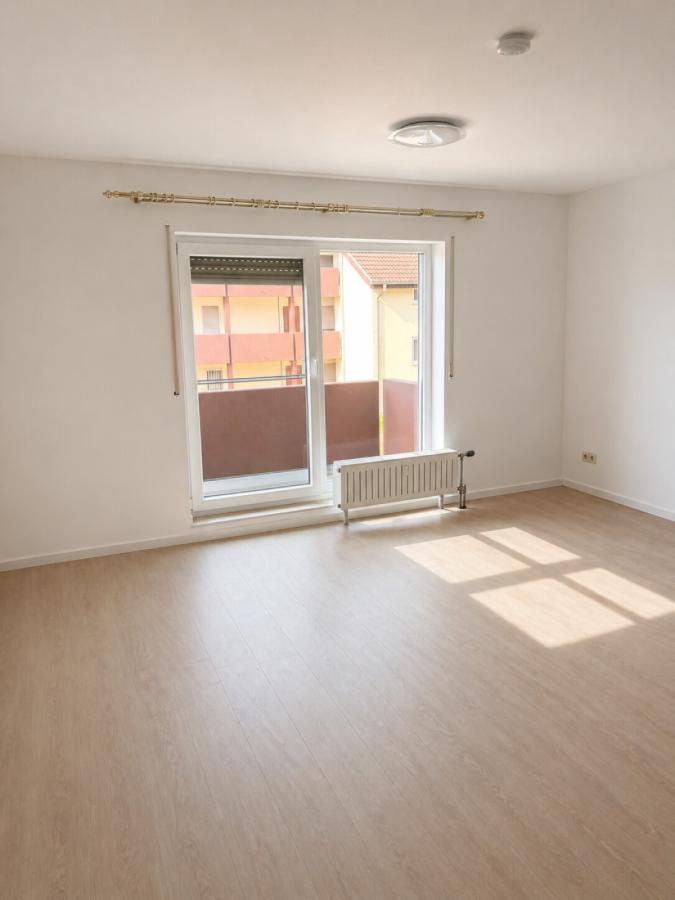 Heller Wohn-und Schlafbereich mit Zugang zum Balkon