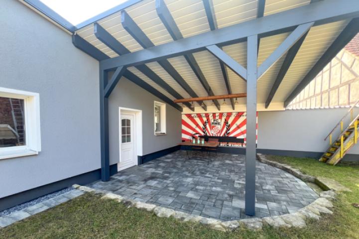Carport, der sich als überdachte Terrasse deffiniert