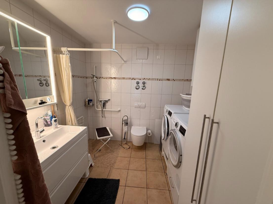 Bad mit Dusche und Waschmaschine und Trocknerstellplatz