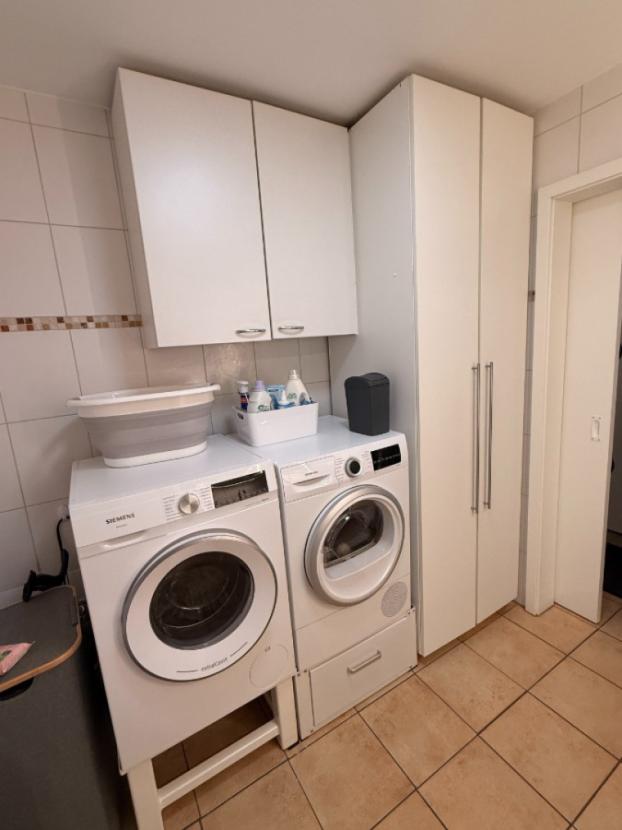 Bad mit Dusche und Waschmaschine und Trocknerstellplatz