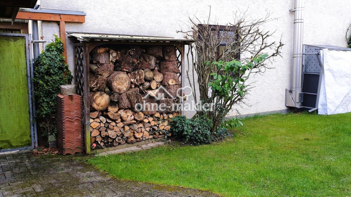 Garteneingang mit Holzlagern