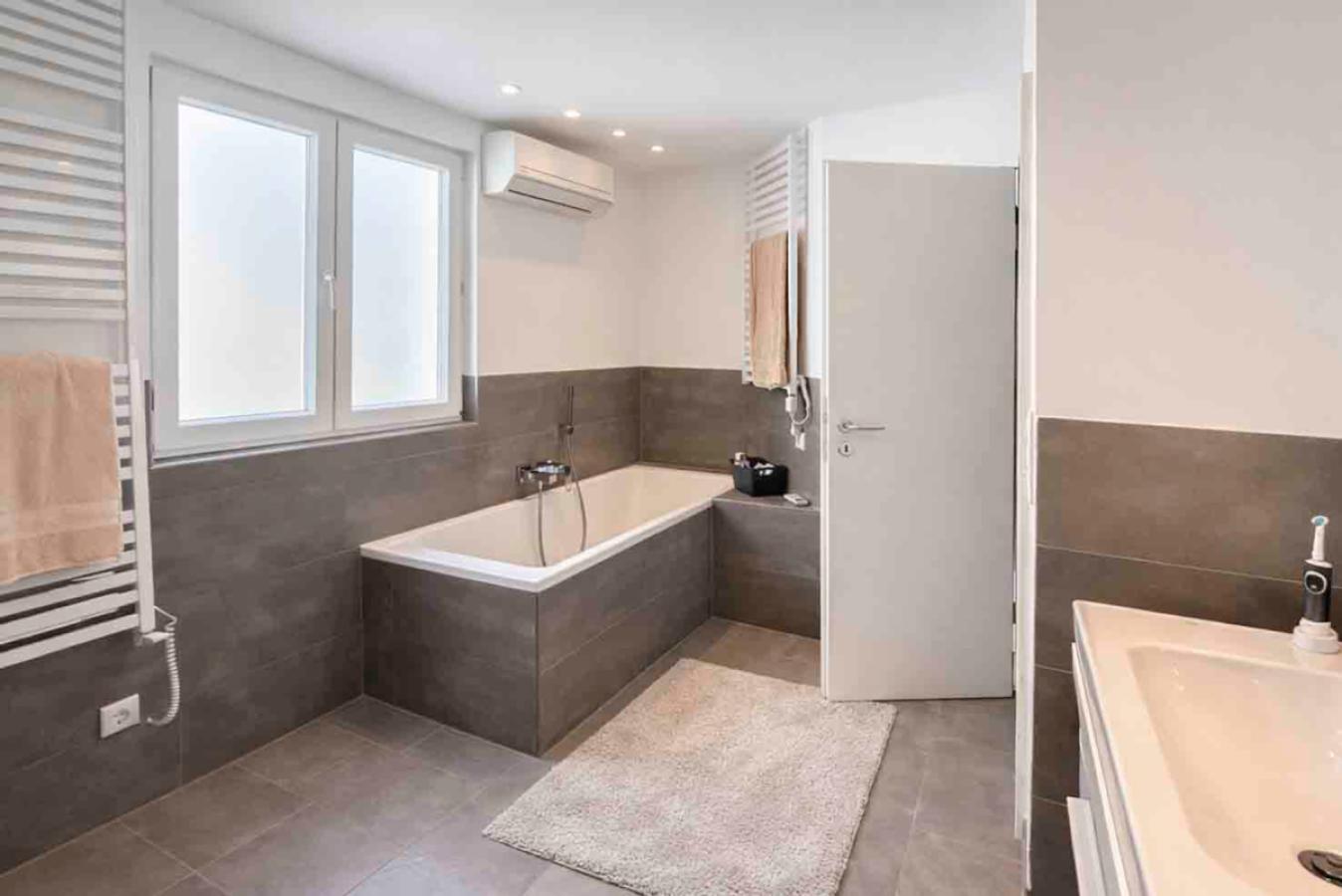 Modernes Tageslichtbad mit Badewanne und Duschtempel
