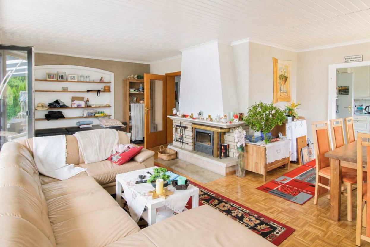 Wohnzimmer mit Kamin und Zugang zum Garten