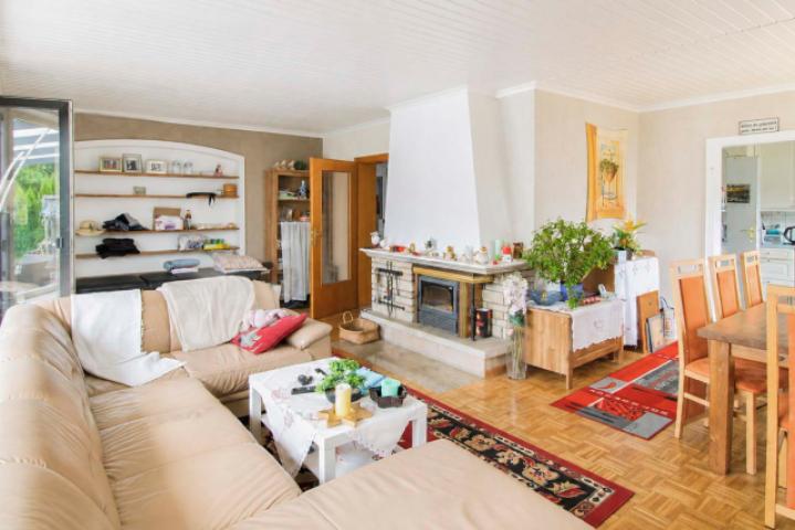 Wohnzimmer mit Kamin und Zugang zum Garten