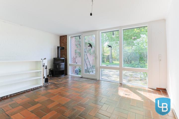 Zimmer mit Kamin und Zugang zum Kellergeschoss