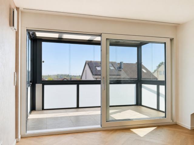 Heller Wohnbereich mit verglastem Wintergarten und Weitblick