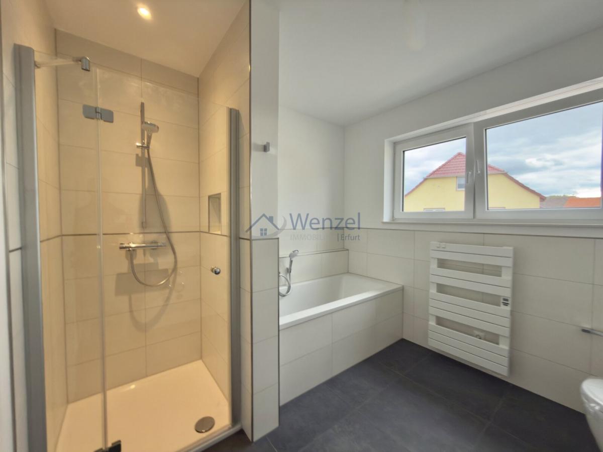 Modernes Badezimmer mit begehbarer Dusche und Handtuchtrockner