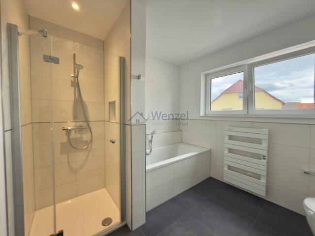 Modernes Badezimmer mit begehbarer Dusche und Handtuchtrockner