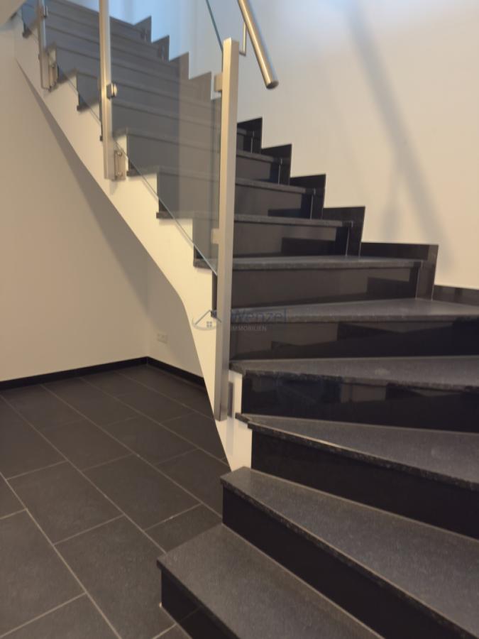Moderne Treppe mit Glasgeländer und hochwertiger Metallhandlauf