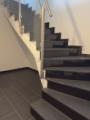 Moderne Treppe mit Glasgeländer und hochwertiger Metallhandlauf