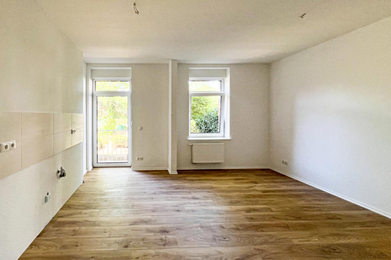 Wohnzimmer mit offener Küche und Balkon