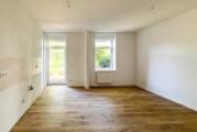 Wohnzimmer mit offener Küche und Balkon