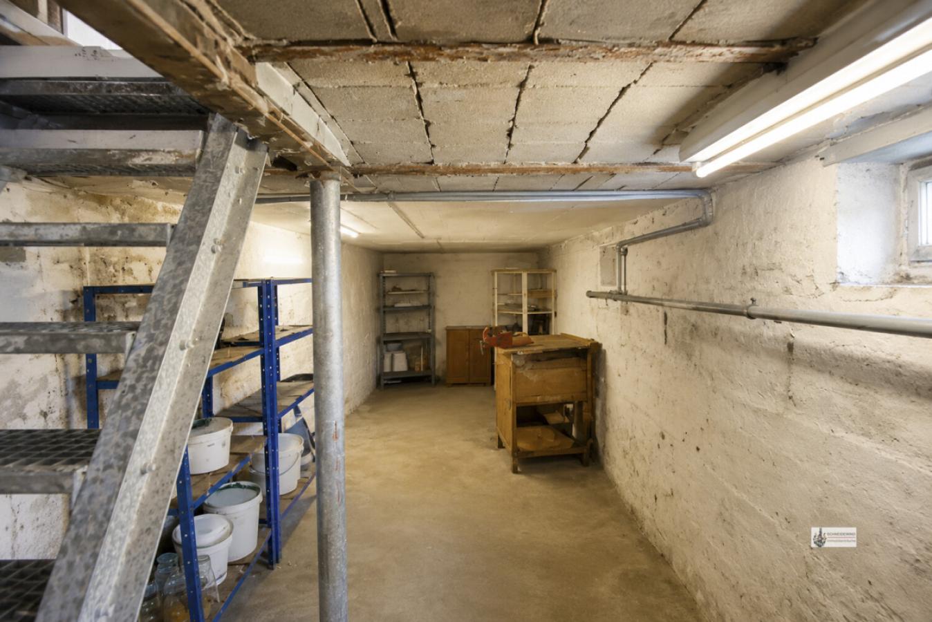 Kellerraum mit Metalltreppe und Werkbank