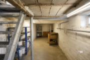 Kellerraum mit Metalltreppe und Werkbank