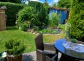 Sonniger Garten mit Teich und Laube
