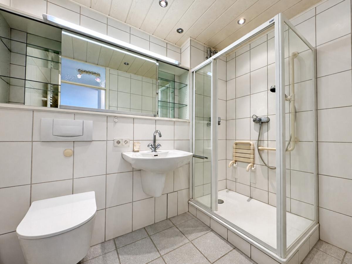 Gefliestes Badezimmer mit Dusche und WC