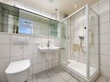 Gefliestes Badezimmer mit Dusche und WC