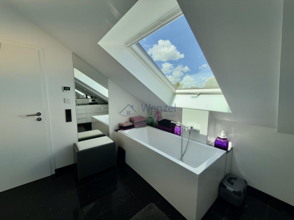 Luxuriöses Badezimmer mit Dachfenster und freistehender Wanne unter Panorama-Ausblick KI generiert