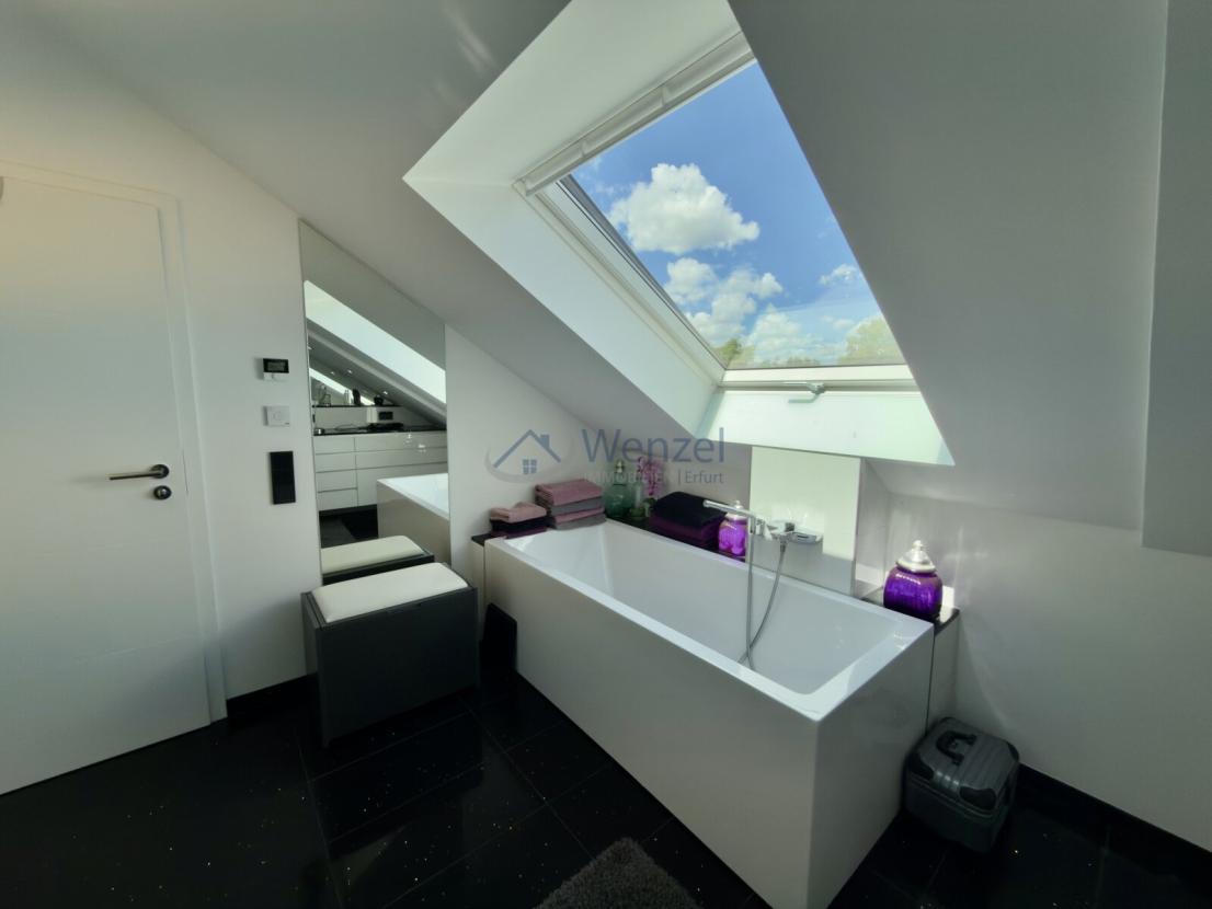 Luxuriöses Badezimmer mit Dachfenster und freistehender Wanne unter Panorama-Ausblick KI generiert