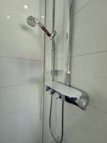 Moderne Duschanlage mit Thermostat und praktischer Ablageflächengestaltung