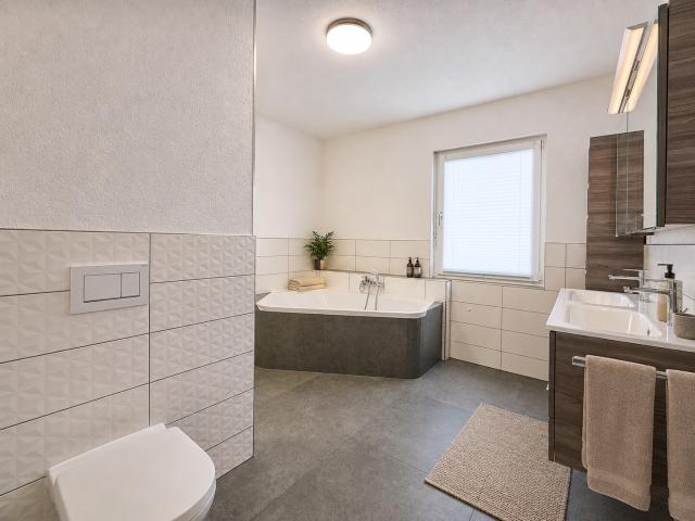 Hauptbad mit Doppelwaschbecken und Badewanne