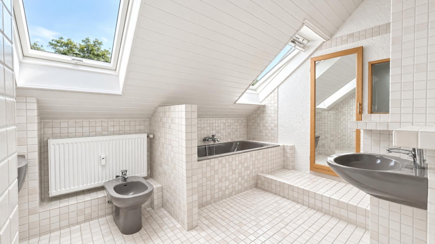 Helles minimalistisches Dachbad mit Oberlichtern