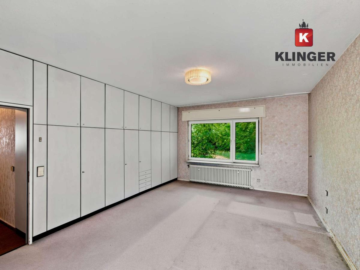 Schlafzimmer mit Einbauschränken und Zugang zum Außenbereich