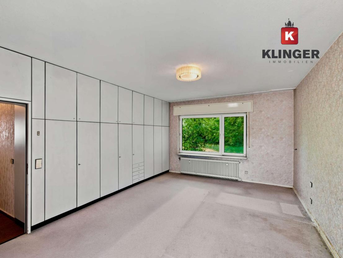 Schlafzimmer mit Einbauschränken und Zugang zum Außenbereich