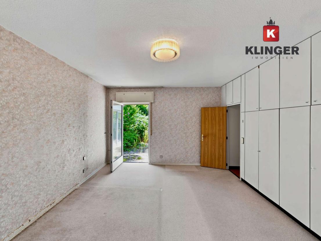 Schlafzimmer mit Einbauschränken und Zugang zum Außenbereich