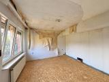 Aufgeräumtes Zimmer mit sichtbaren Bauschäden