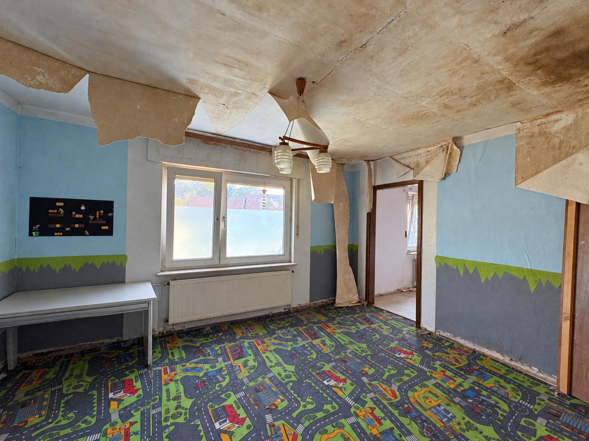 Aufgeräumtes, aber renovierungsbedürftiges Kinderzimmer