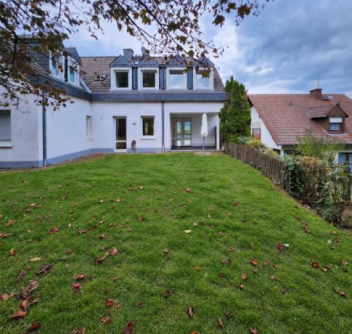 7 Blick vom der Wohnung zugeordneten Gartenanteil auf die Terrasse und Wohnung